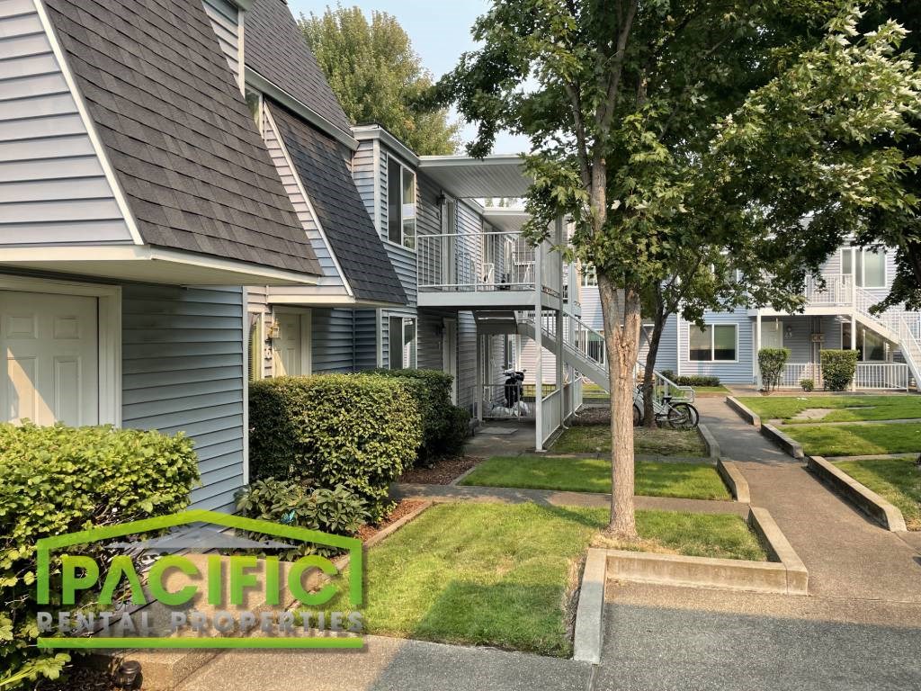 a row of houses with a tree in the yard