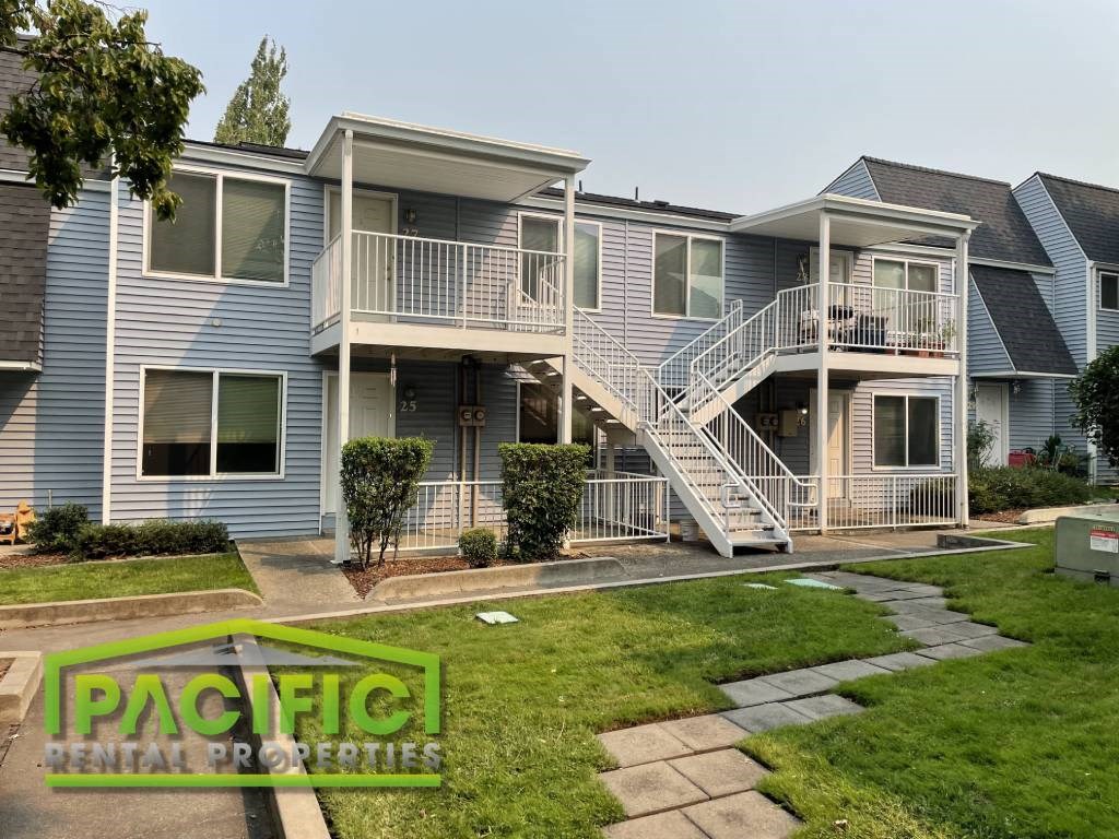 a blue house with stairs and a yard