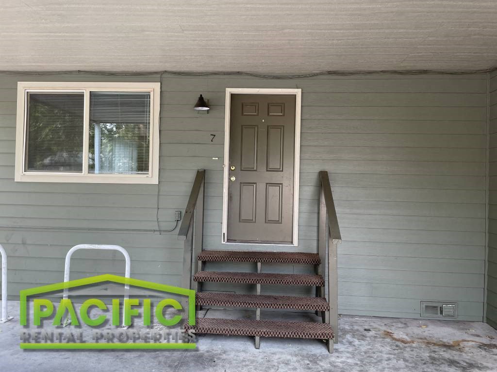 the front door of a house with stairs and a wheelchair