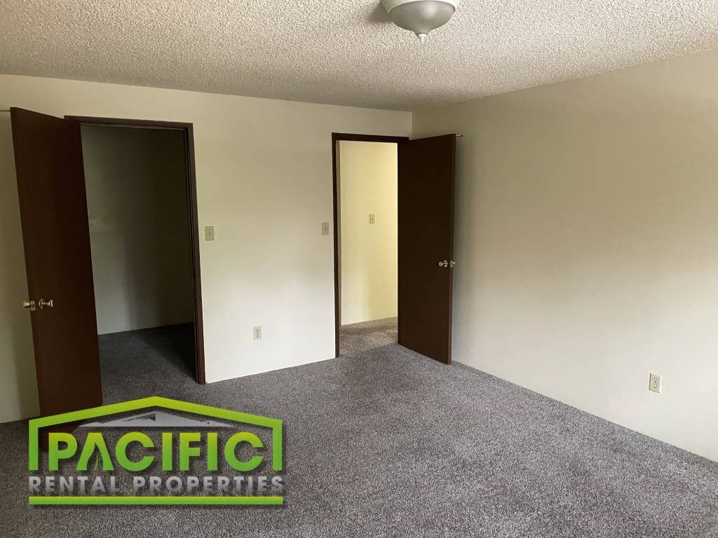 an empty room with three doors and a carpeted floor