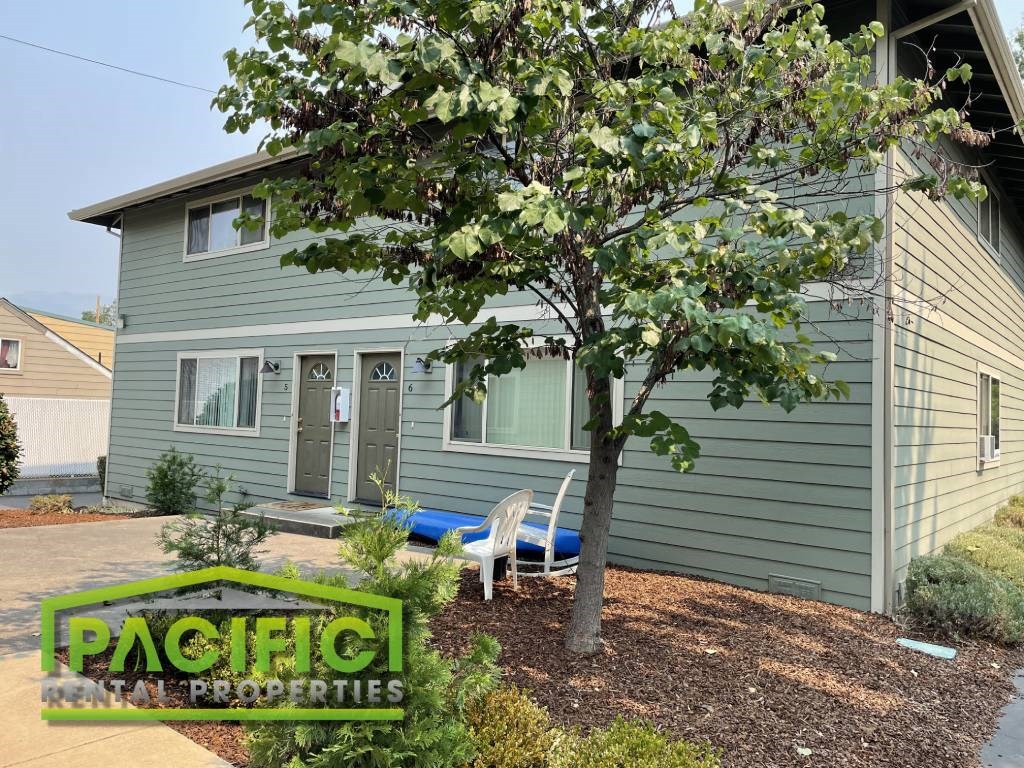 a blue house with a tree in front of it