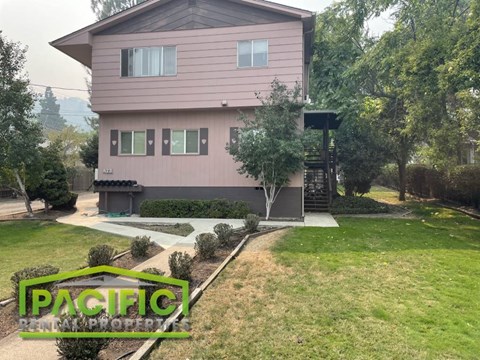 a house with a yard and a sidewalk in front of it