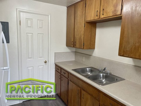 a small kitchen with a sink and wooden cabinets
