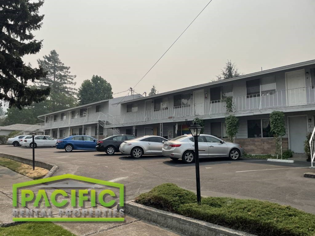 a parking lot with cars in front of an apartment building