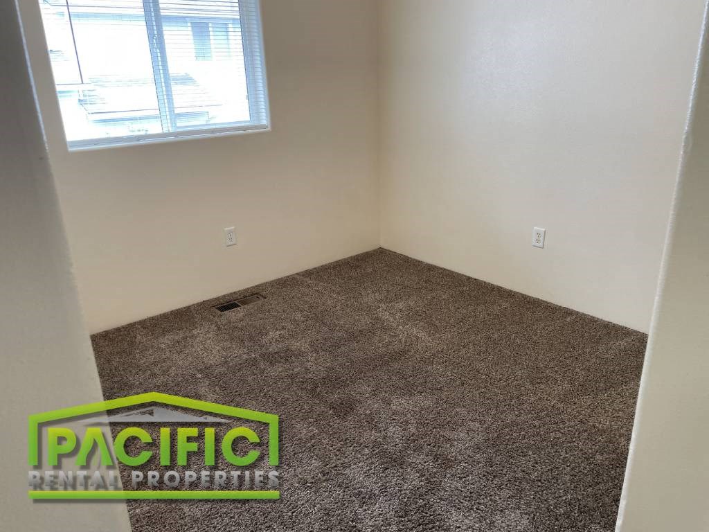 an empty room with carpet and a window