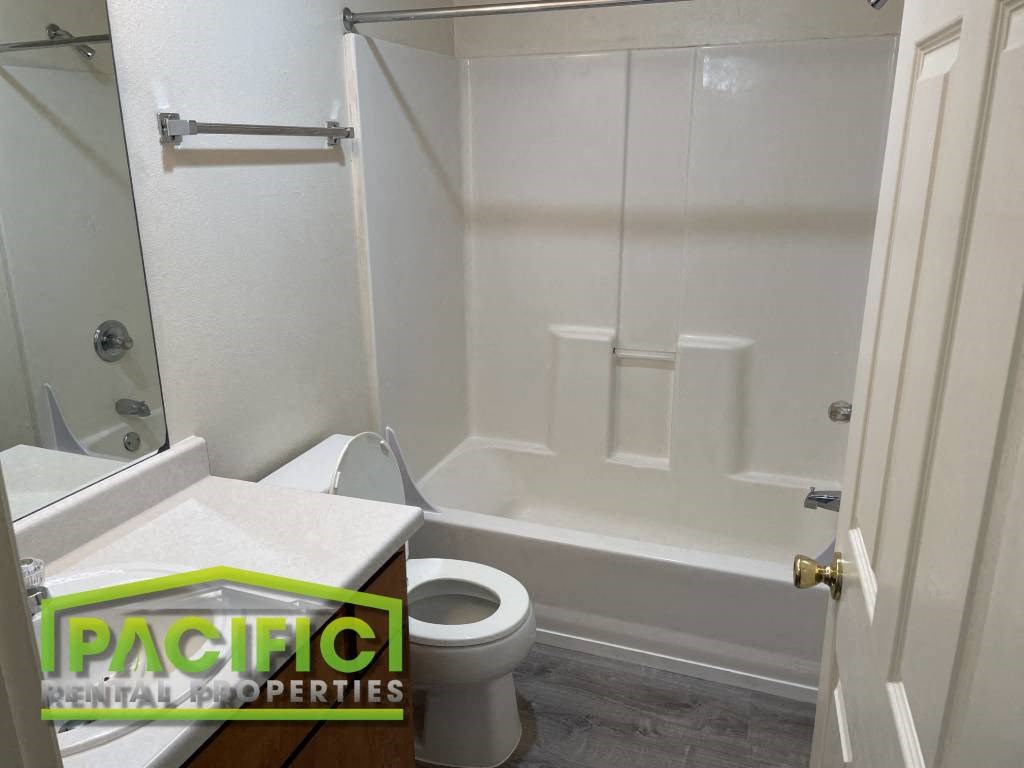 a bathroom with a toilet and a tub and a sink