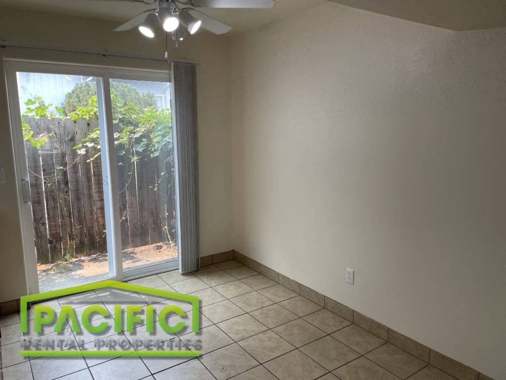 a empty living room with a sliding glass door to a patio