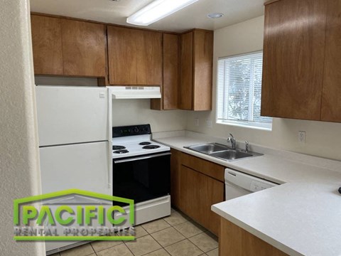 a small kitchen with white appliances and wooden cabinets