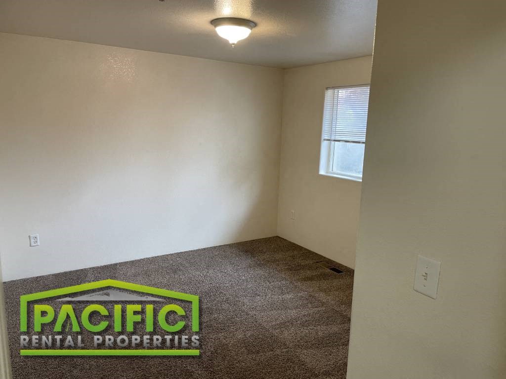 an empty room with a carpeted floor and a window