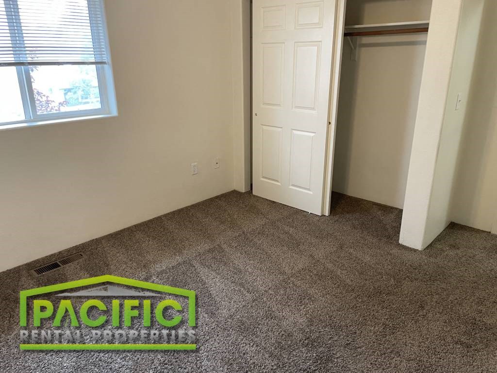 a carpeted room with a door and a pacific logo on the floor