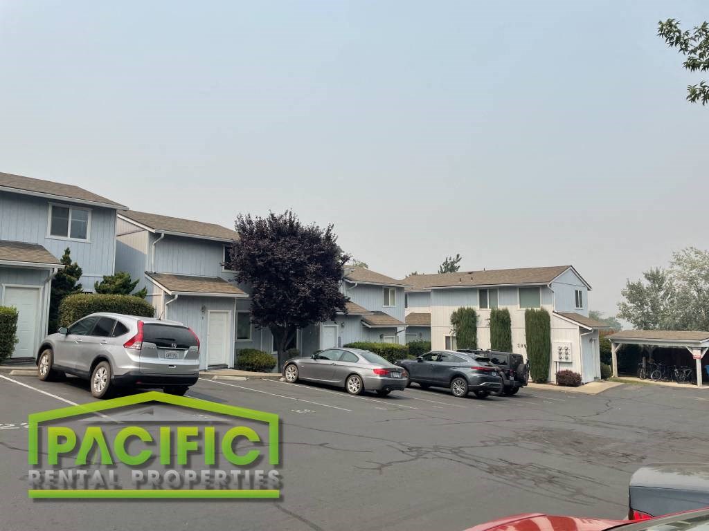 a parking lot with cars parked in front of apartment buildings