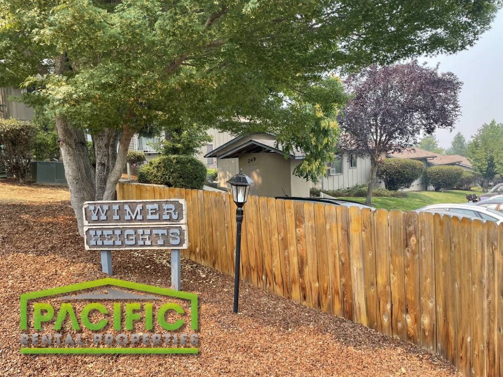 a street sign sitting in front of a wooden fence