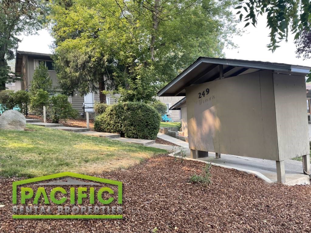 a public restroom in a yard in front of a house