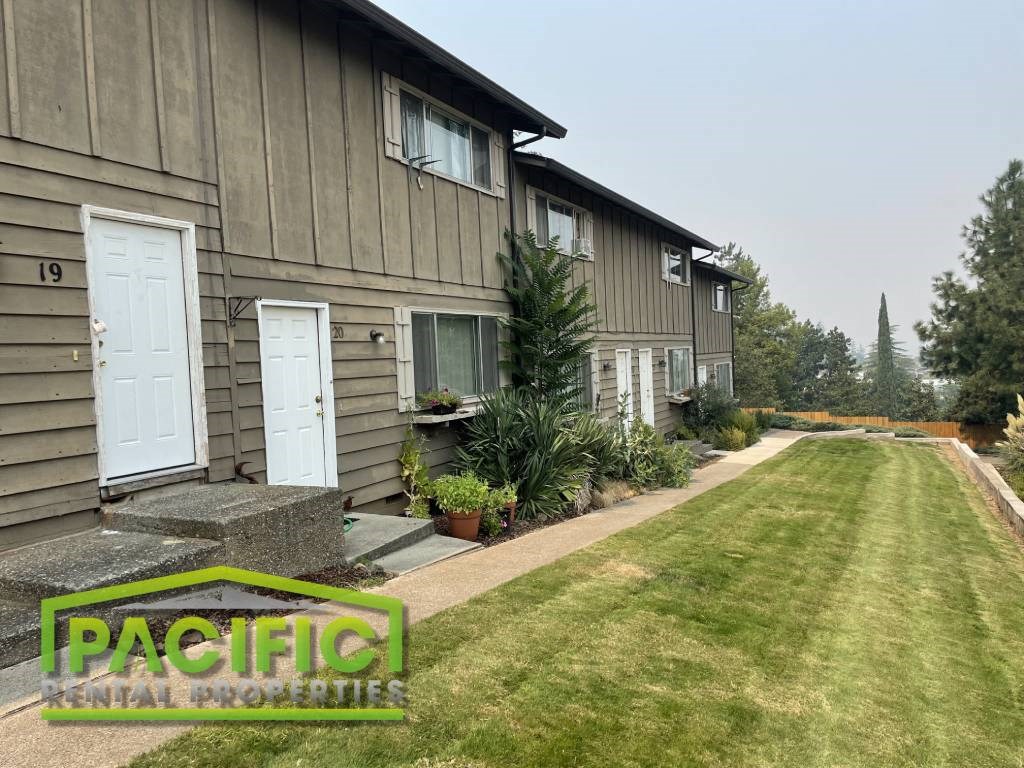 a home with a lawn and a sidewalk in front of it