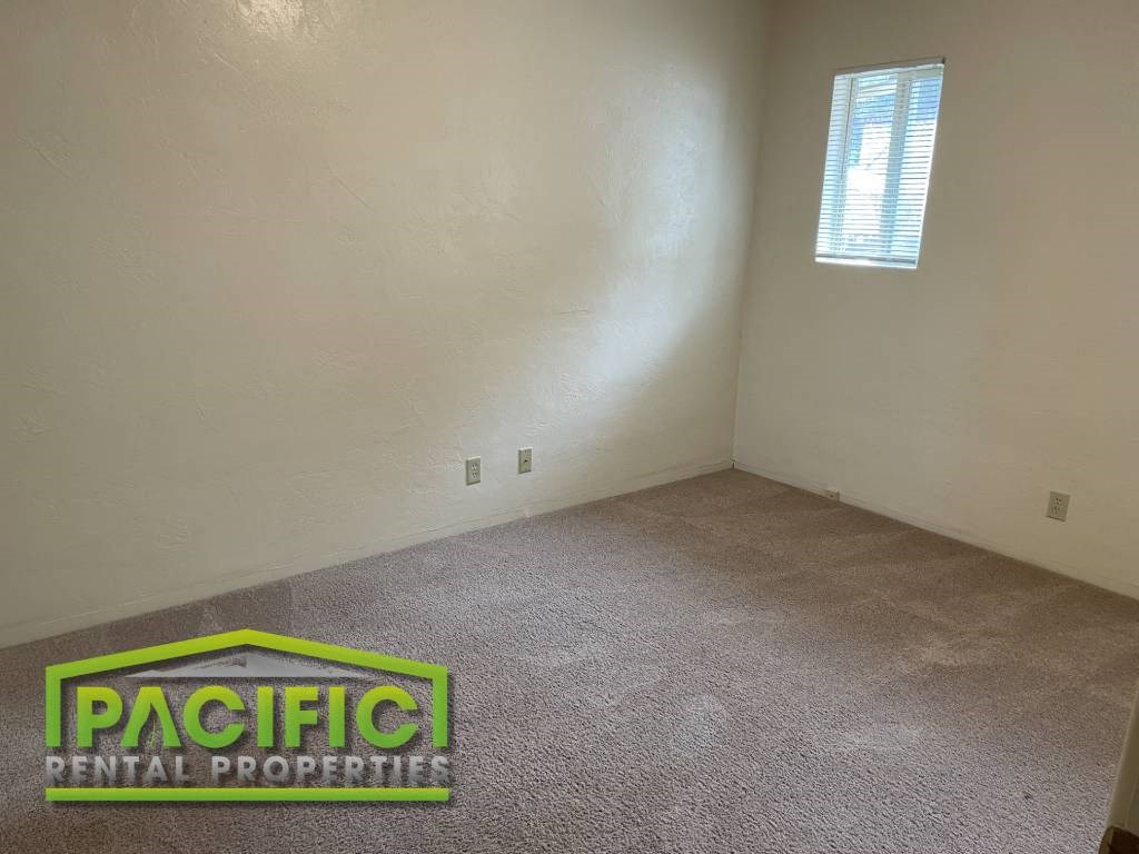 an empty room with a pacific rental property sign on the floor