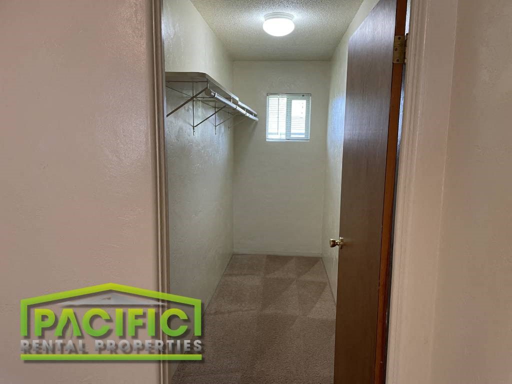 a long hallway with a closet and a window