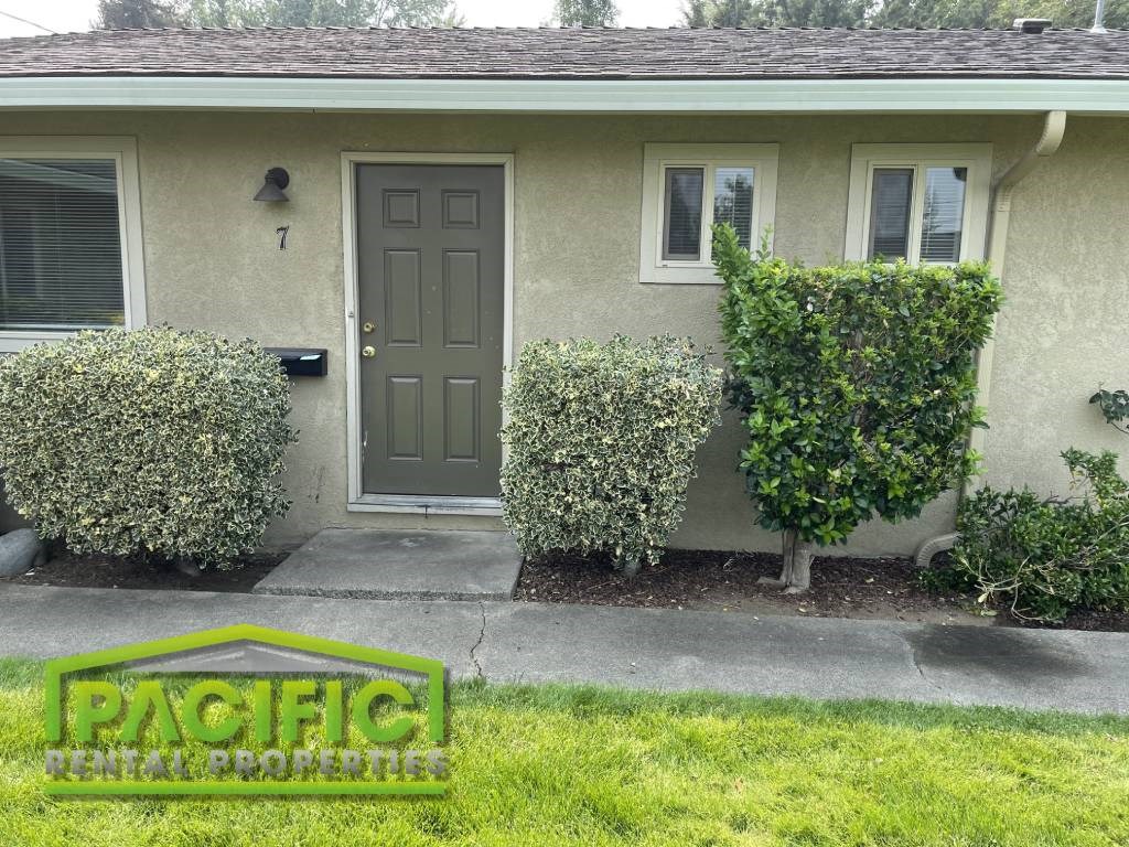 a house with two bushes in front of it
