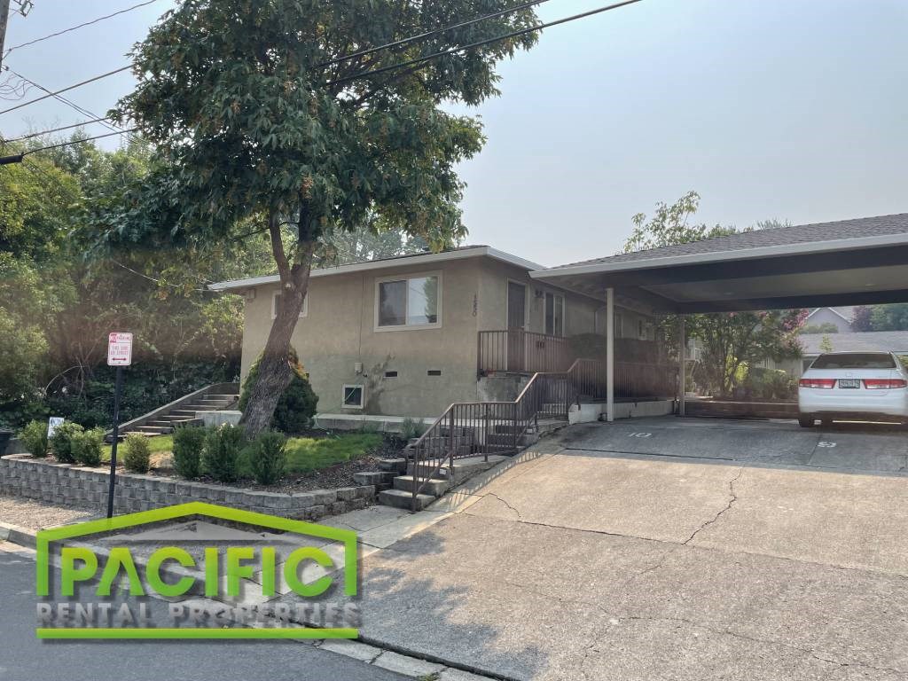 a house with a parking lot and a tree