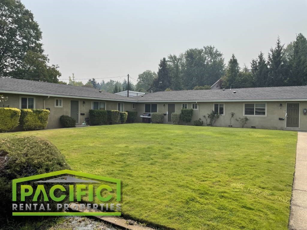 a green lawn in front of a row of houses