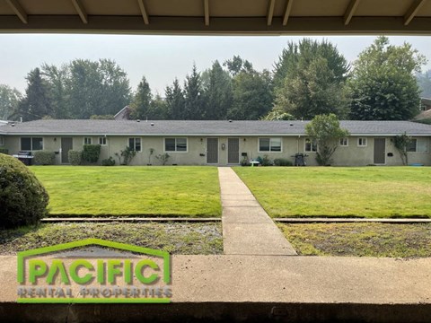 a house with a lawn and trees in the background