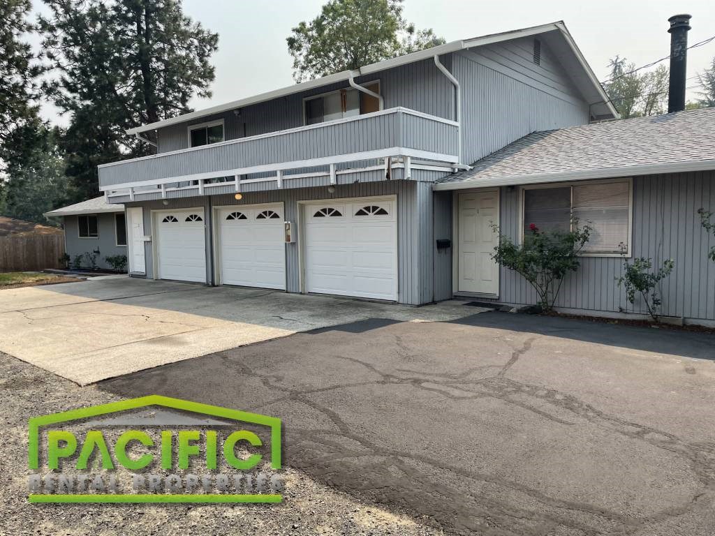 A two-story house with a garage and a driveway in front.