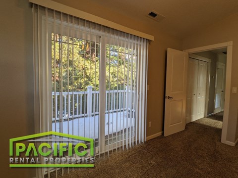 a living room with a large window with white sheer curtains