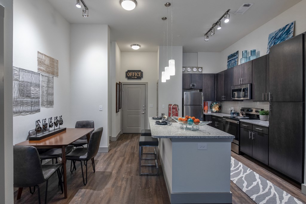 a kitchen and dining room with a marble counter top and stainless steel appliances