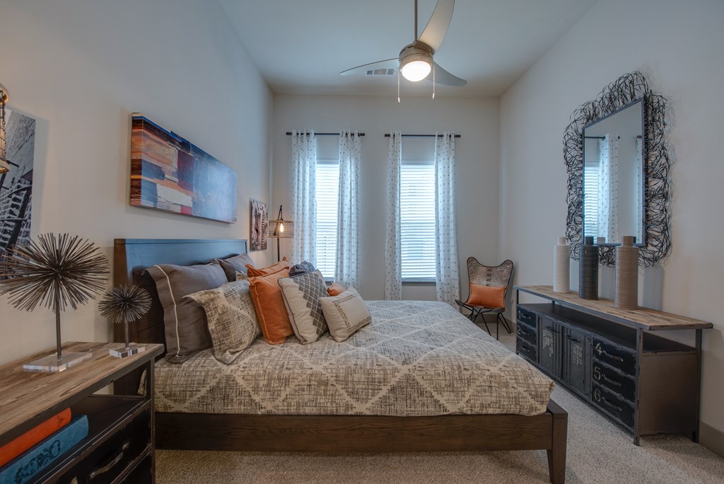 a bedroom with a large bed and a ceiling fan