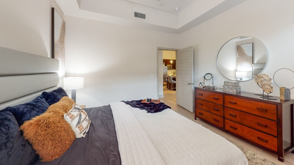 a bedroom with a large bed and a dresser