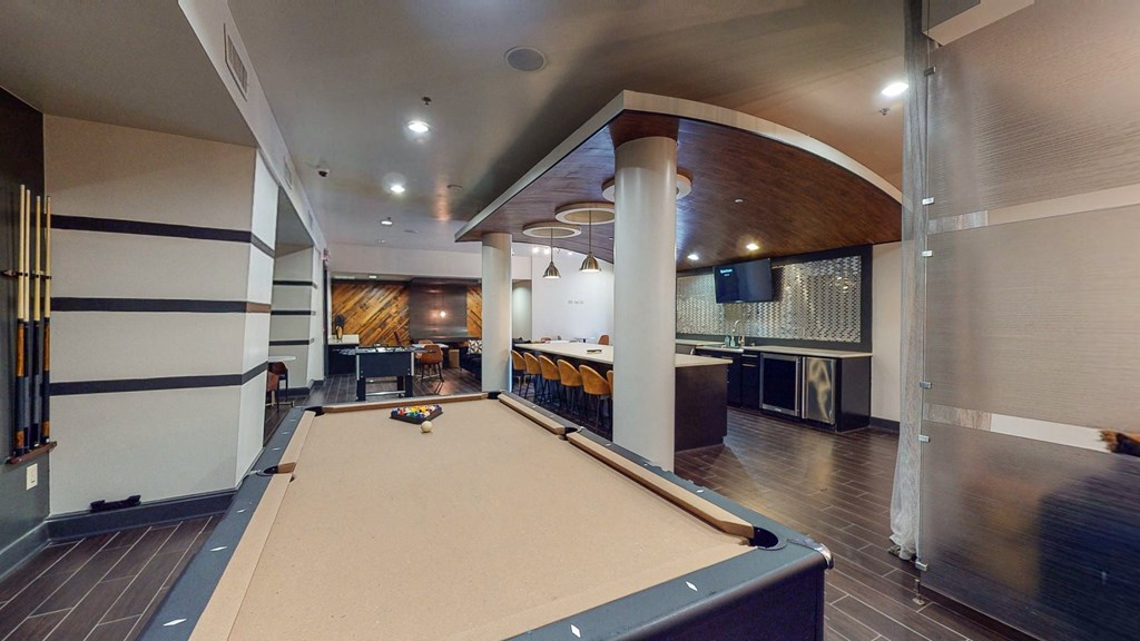 a game room with a pool table and a bar