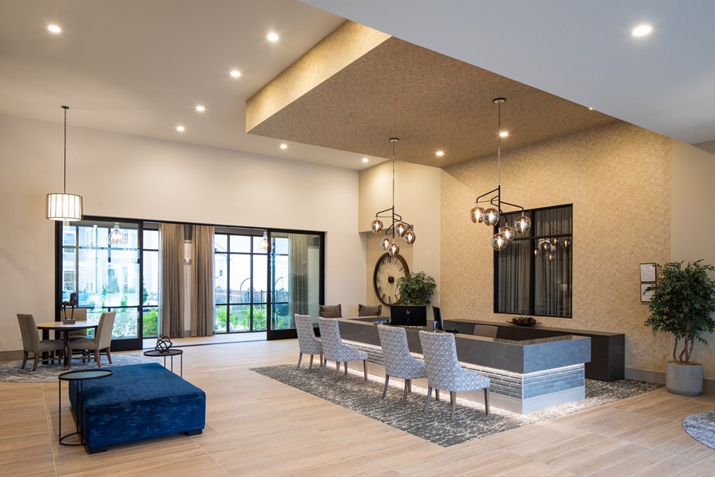 a lobby with a blue couch and a table with chairs