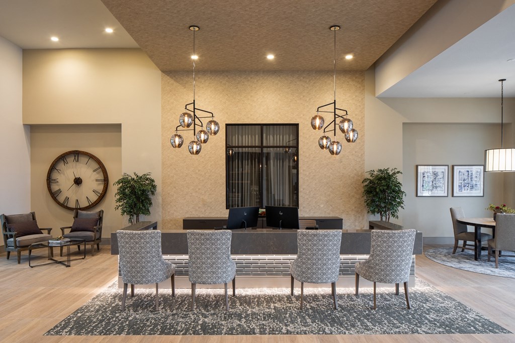 a lobby with a large table and chairs and a clock on the wall