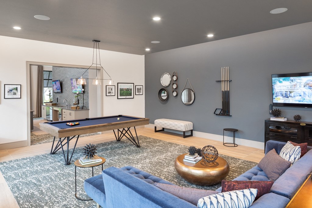 a living room with a pool table and a tv