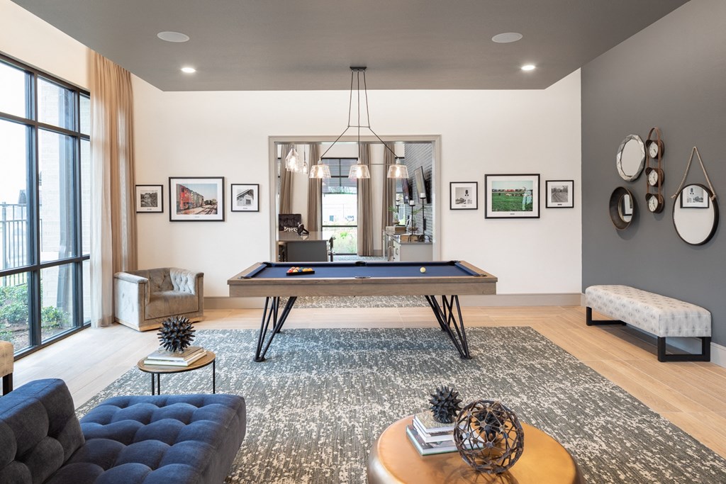 a living room with a pool table in the center of it