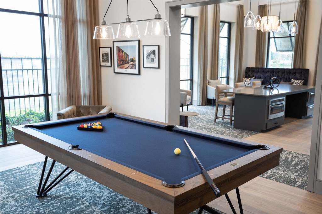 a billiards table in a living room with a dining area and a bar