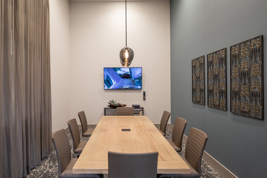 a conference room with a large wooden table and a television on the wall