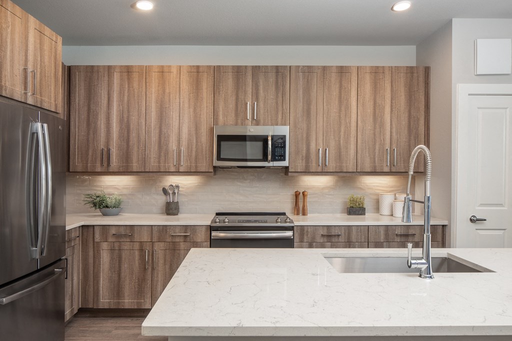 a kitchen with wooden cabinets and a marble counter top