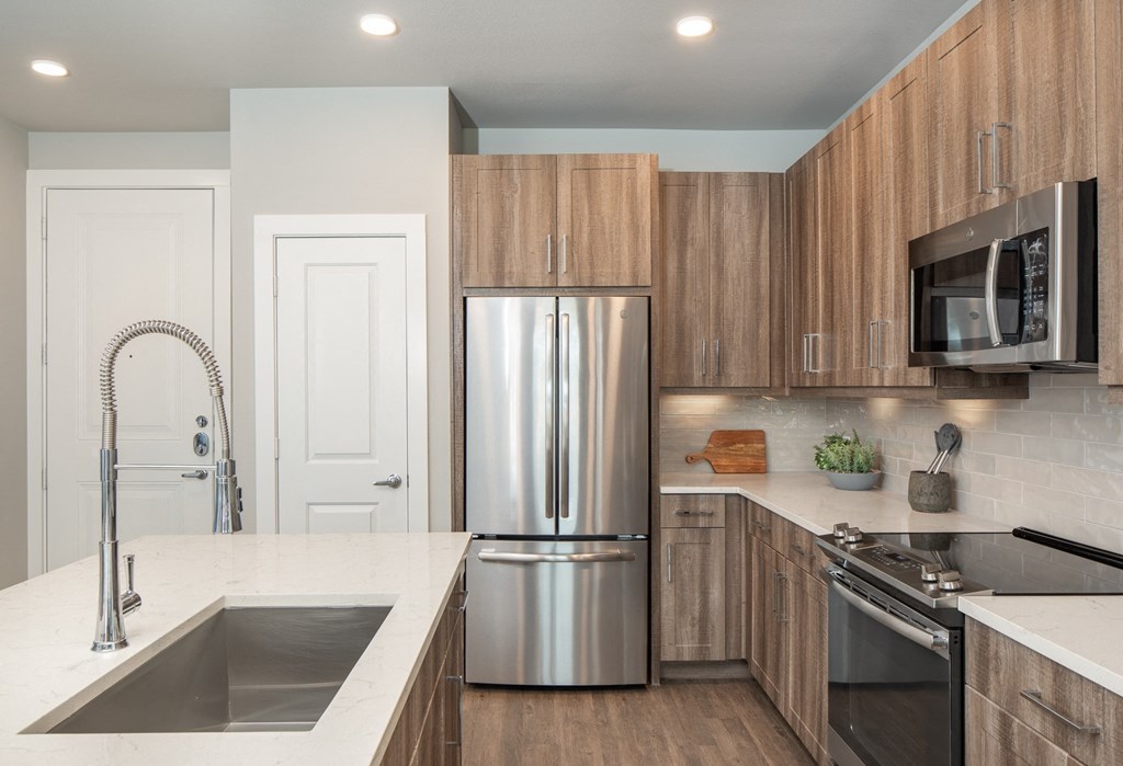 a modern kitchen with stainless steel appliances and wooden cabinets