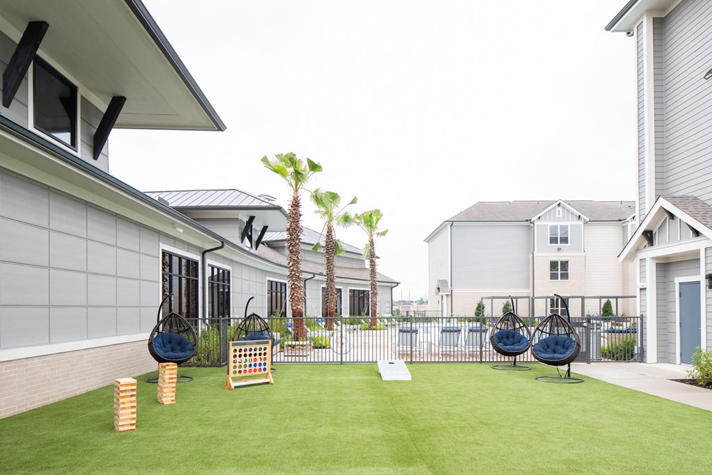 a yard with swings and a fence with houses in the background