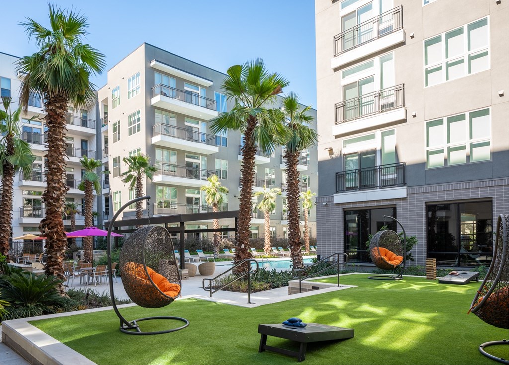 a courtyard with a pool and palm trees in front of buildings
