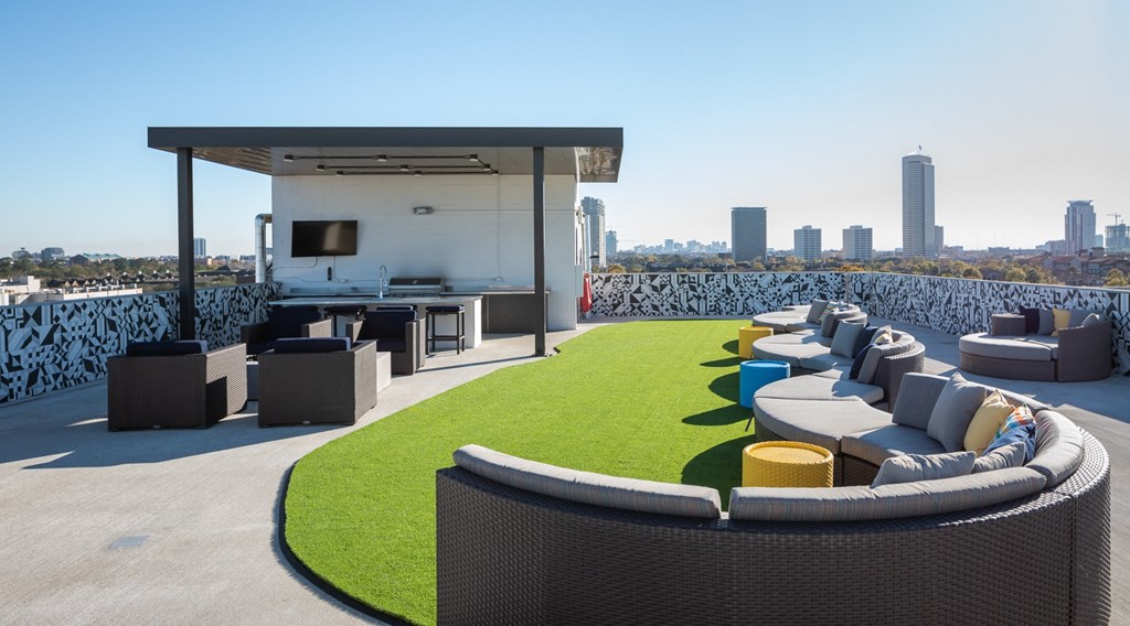 a roof top patio with furniture and a city skyline in the background