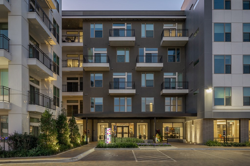 an empty parking lot in front of an apartment building
