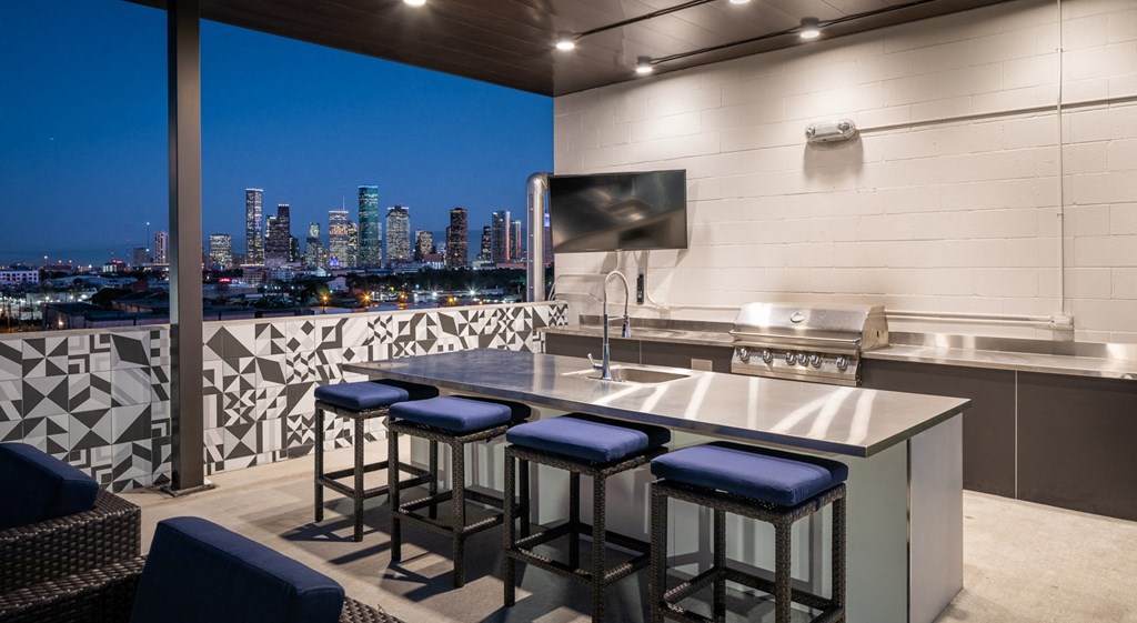 a kitchen with a bar and a view of a city at night
