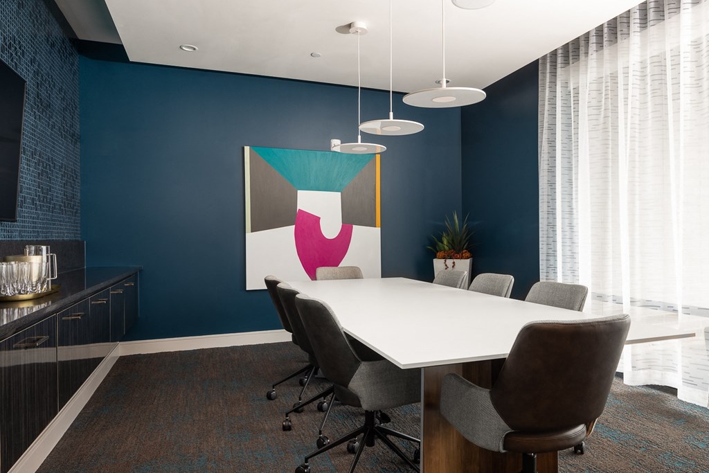a conference room with blue walls and a white table and chairs