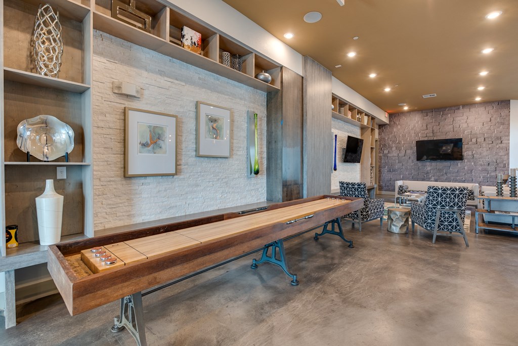 a long wooden bench in a room with chairs and a television