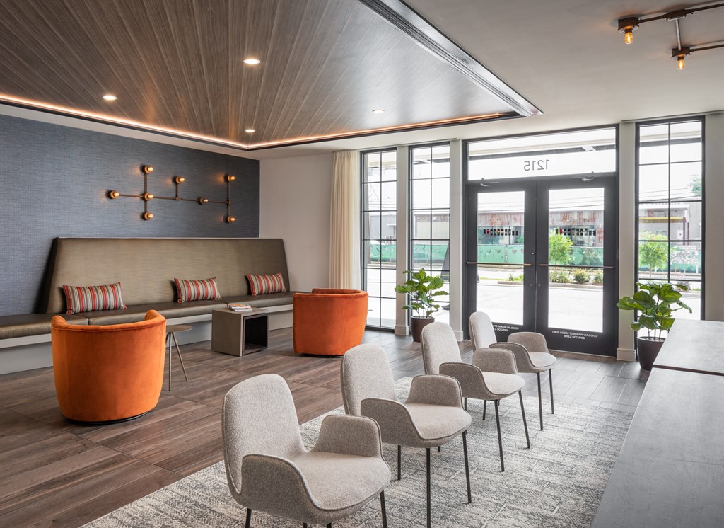 a lounge area with chairs and tables and glass doors