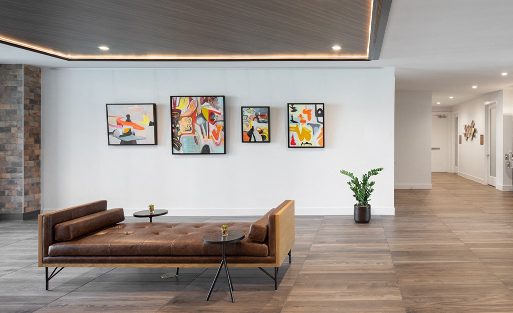 a living room with a couch and paintings on the wall