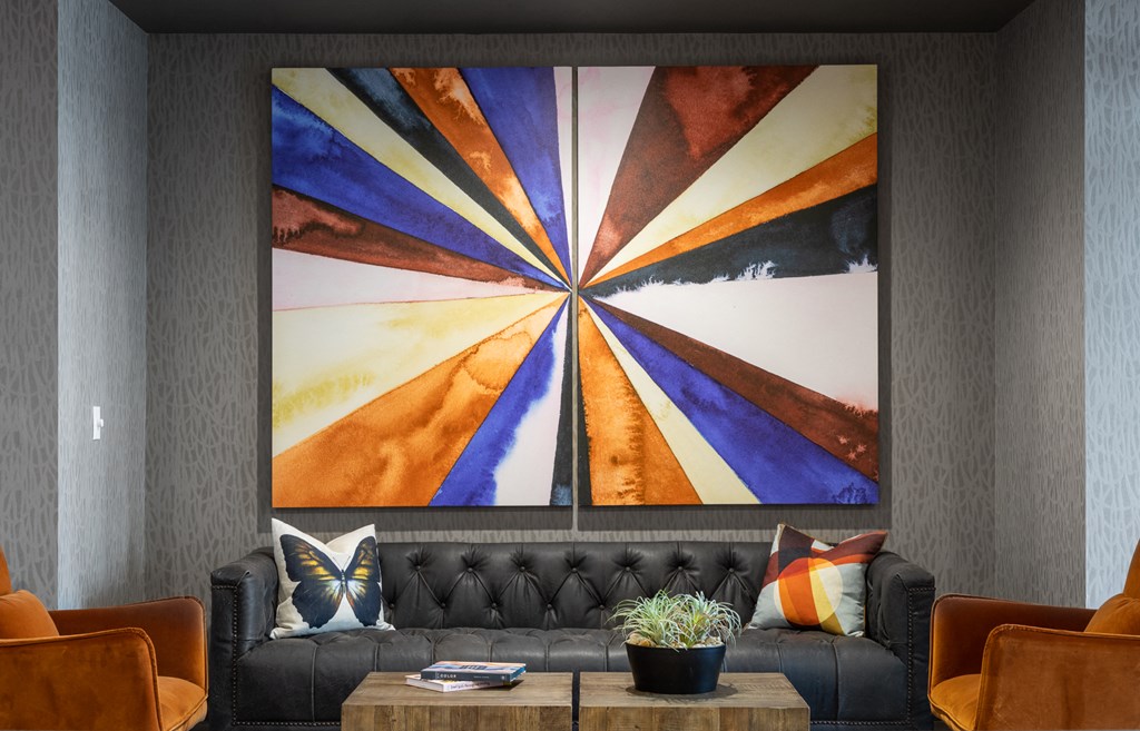 a living room with a couch and a table with a painting on the wall