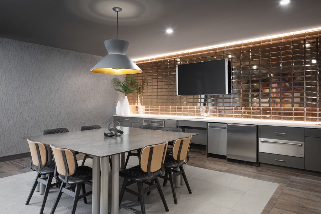 a dining room with a table and chairs and a kitchen with a tv