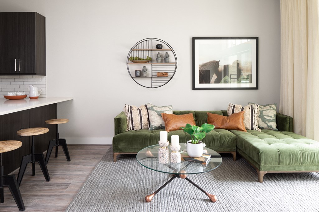 a living room with a green couch and a glass table